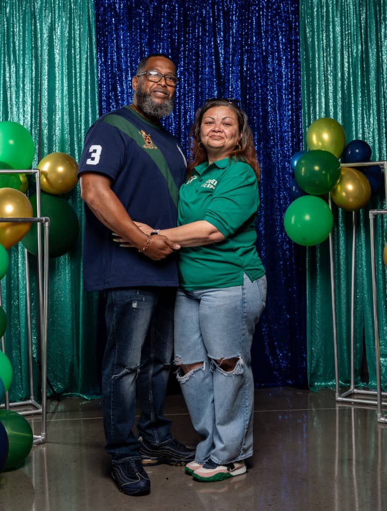 Couple holding hands at a church anniversary event.